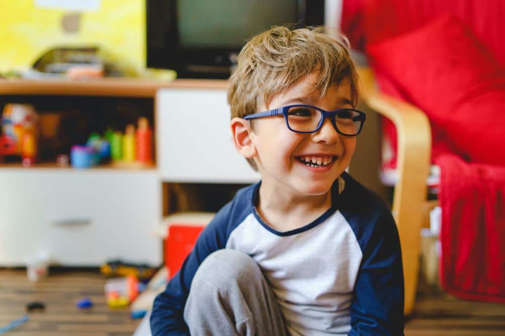 young-boy-smiling-while-playing boy laughing while playing inside